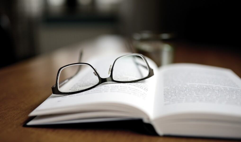 Briller der ligger på enbog