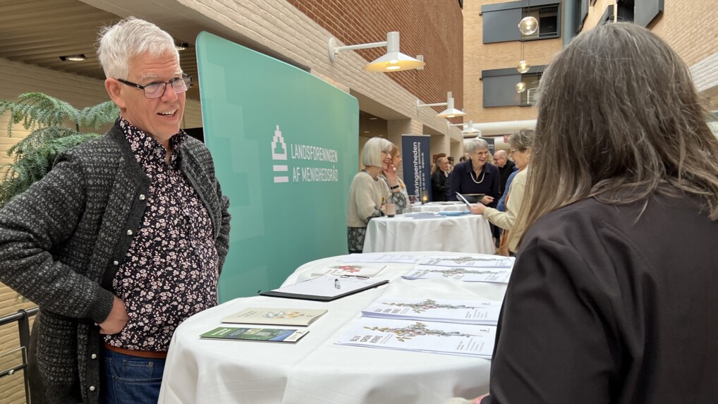 Provst Keld Balmer Hansen taler med kvinde ved sin stand